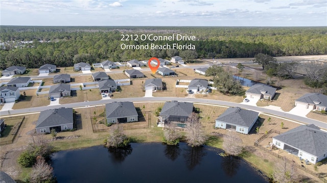 bird's eye view with a residential view, a view of trees, and a water view