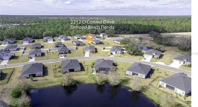 aerial view with a residential view, a view of trees, and a water view