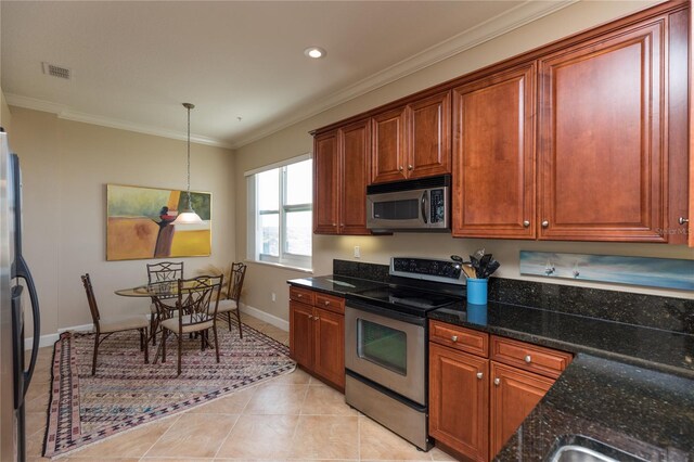 kitchen with light tile patterned flooring, appliances with stainless steel finishes, decorative light fixtures, dark stone counters, and crown molding