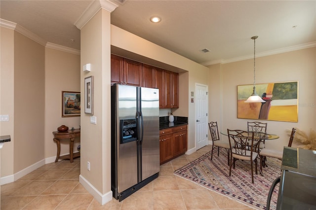 kitchen featuring crown molding, light tile patterned floors, decorative light fixtures, and stainless steel fridge