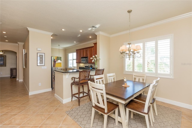 tiled dining area featuring an inviting chandelier and ornamental molding