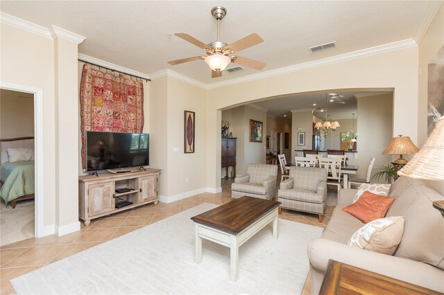 tiled living room featuring ornamental molding and ceiling fan with notable chandelier