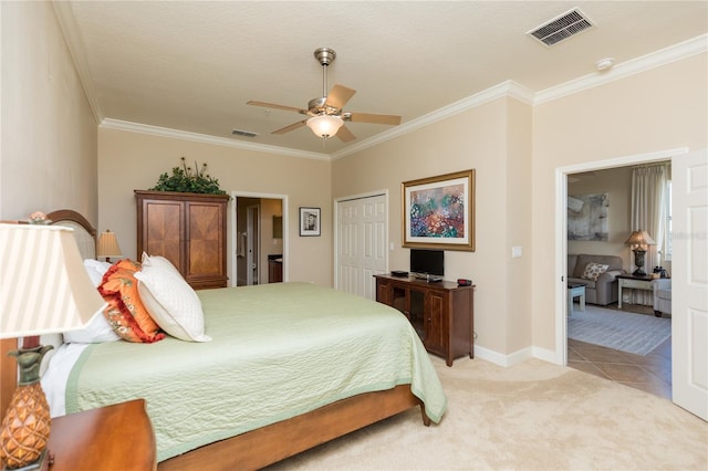 bedroom with light carpet, ornamental molding, a closet, and ceiling fan