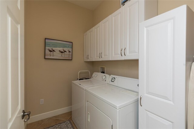 laundry room featuring cabinets, tile patterned floors, and washer and clothes dryer