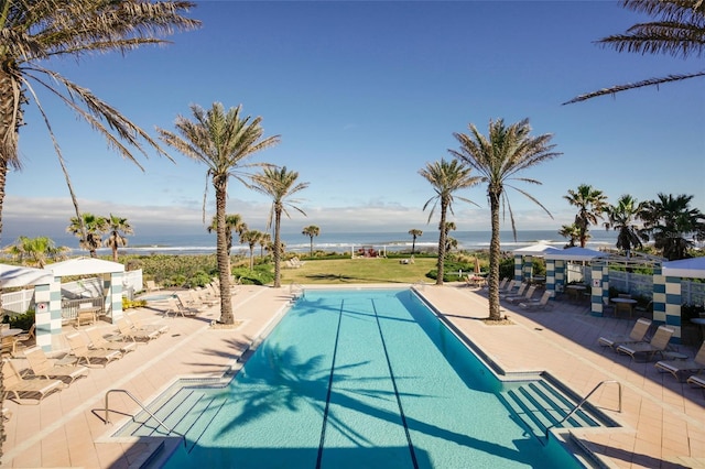 view of swimming pool featuring a patio and a water view