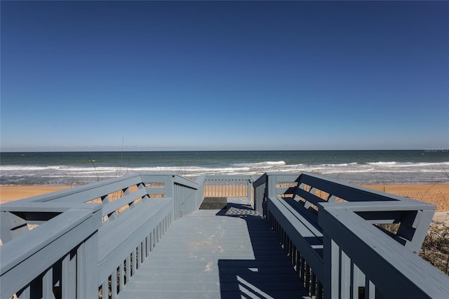 view of community with a water view and a beach view