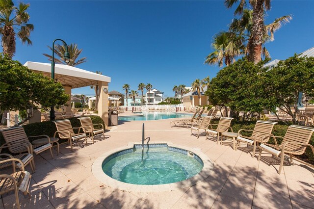 view of pool with a community hot tub and a patio