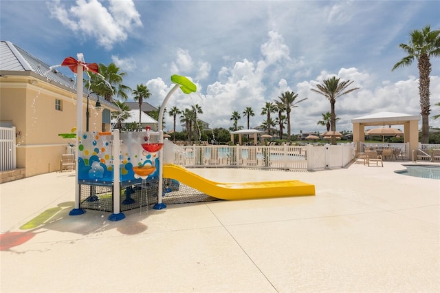 view of playground with a gazebo, a community pool, and a patio area