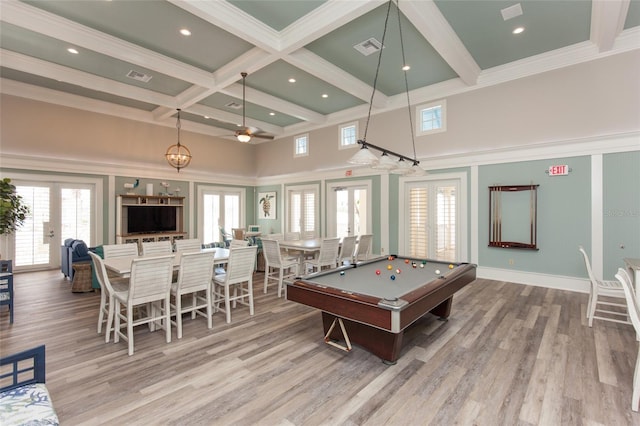 game room with french doors, plenty of natural light, beam ceiling, and light wood-type flooring