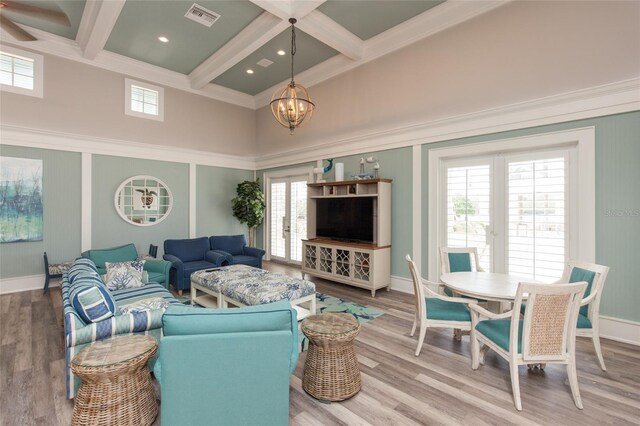 living room featuring french doors, coffered ceiling, beamed ceiling, an inviting chandelier, and hardwood / wood-style flooring