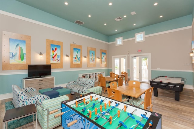 playroom with french doors and light hardwood / wood-style flooring