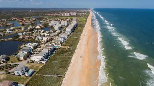 birds eye view of property featuring a beach view and a water view