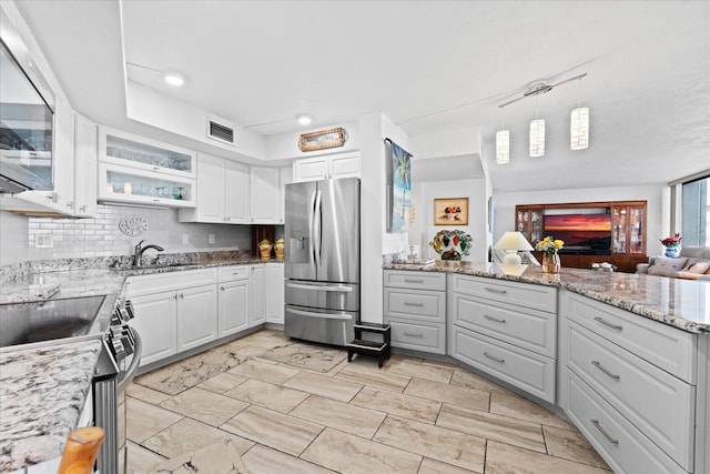 kitchen featuring appliances with stainless steel finishes, sink, pendant lighting, and white cabinets