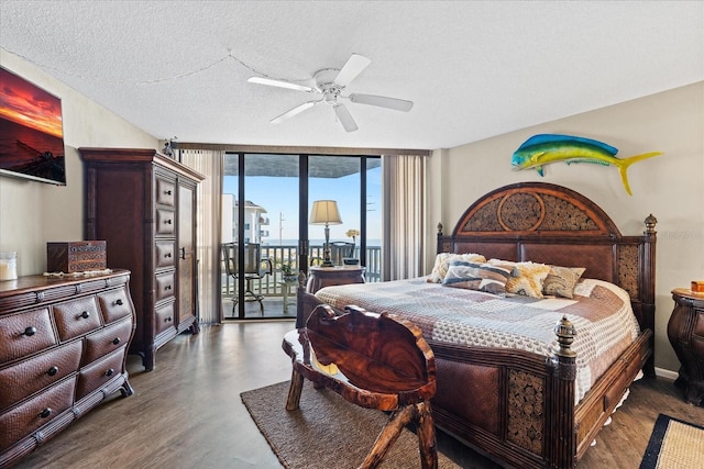 bedroom with floor to ceiling windows, a textured ceiling, access to outside, dark hardwood / wood-style floors, and ceiling fan