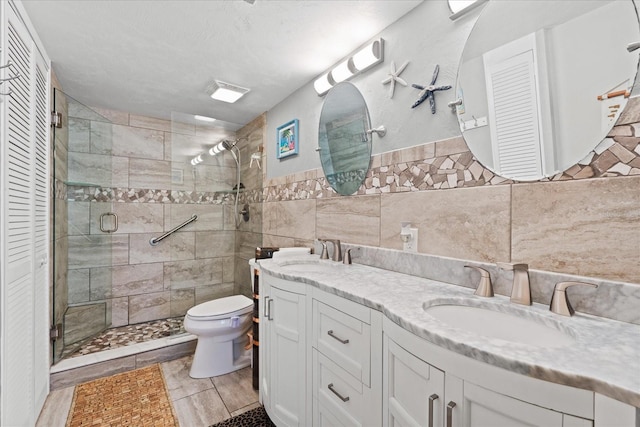 bathroom featuring vanity, a shower with door, tile walls, and toilet