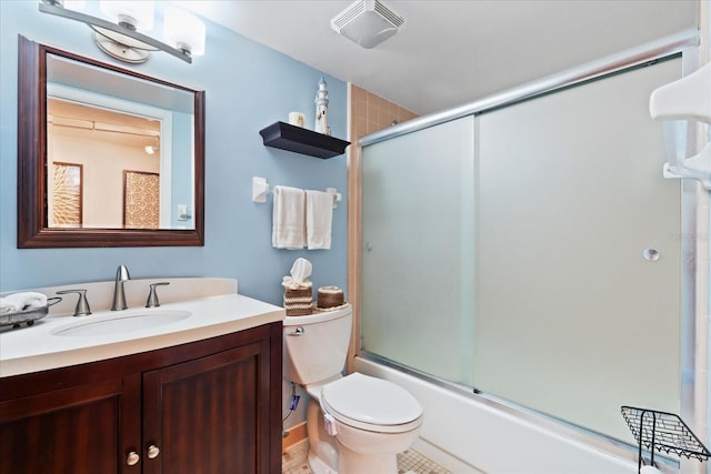 full bathroom with bath / shower combo with glass door, vanity, and toilet