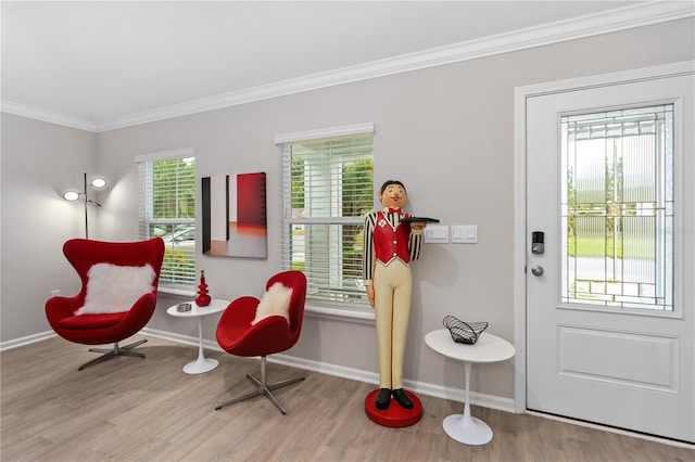 sitting room with ornamental molding and light wood-type flooring