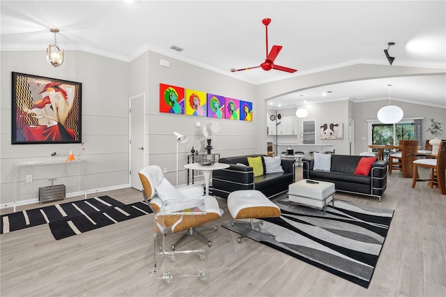 living room featuring vaulted ceiling, ceiling fan, ornamental molding, and light hardwood / wood-style floors