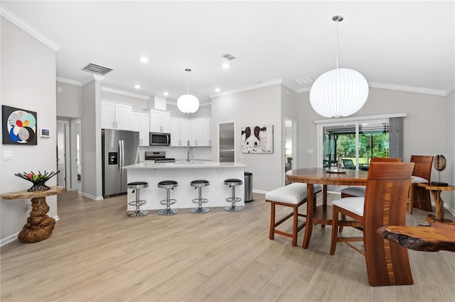 dining area with crown molding and light wood-type flooring