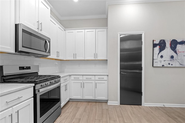 kitchen featuring stainless steel appliances, tasteful backsplash, light stone countertops, ornamental molding, and white cabinets