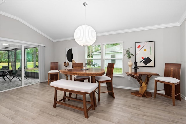 dining space with vaulted ceiling, crown molding, and light wood-type flooring