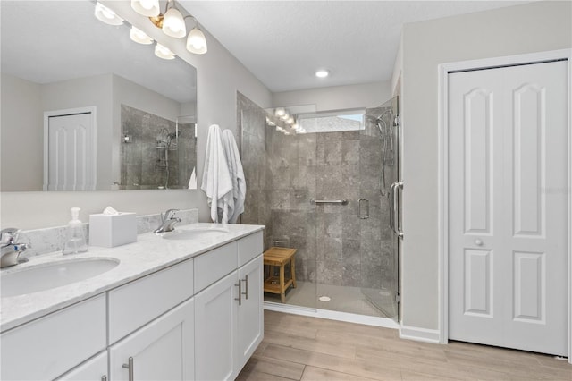 bathroom featuring vanity, wood-type flooring, a textured ceiling, and walk in shower