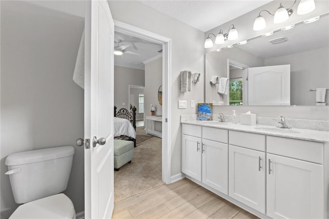 bathroom with vanity, hardwood / wood-style floors, toilet, and ceiling fan