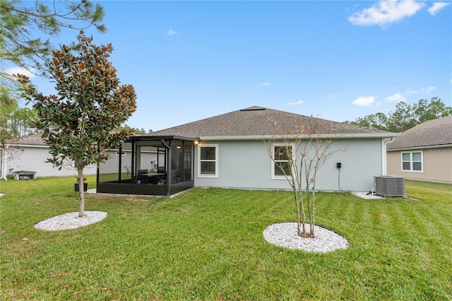 rear view of house with a sunroom, a yard, and cooling unit