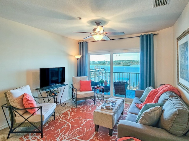 living room with a textured ceiling and ceiling fan