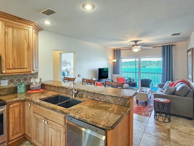 kitchen with sink, stainless steel dishwasher, kitchen peninsula, ceiling fan, and decorative backsplash