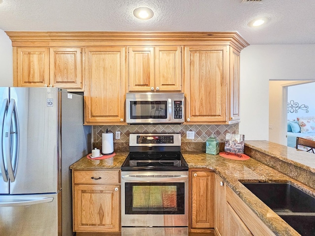 kitchen with backsplash, stainless steel appliances, stone counters, and light brown cabinets