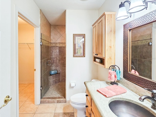 bathroom featuring vanity, tile patterned floors, toilet, and walk in shower