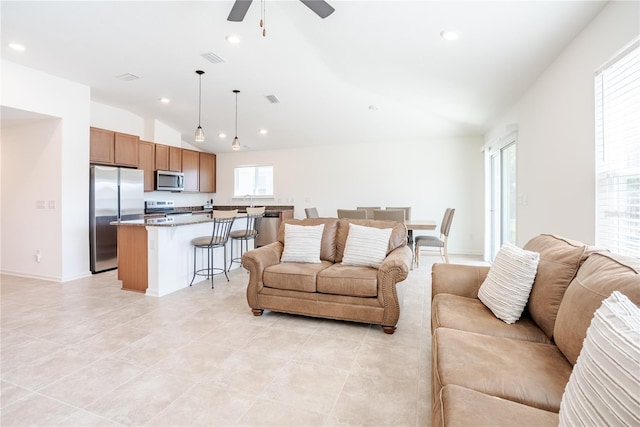 living room featuring ceiling fan, lofted ceiling, and light tile patterned floors