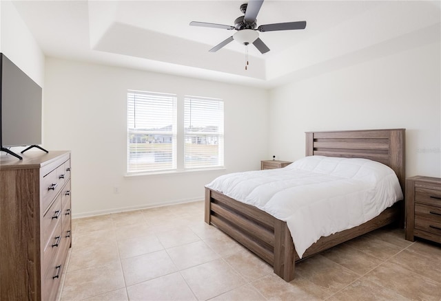 tiled bedroom featuring a tray ceiling and ceiling fan