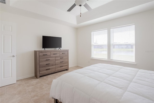 tiled bedroom featuring a raised ceiling and ceiling fan