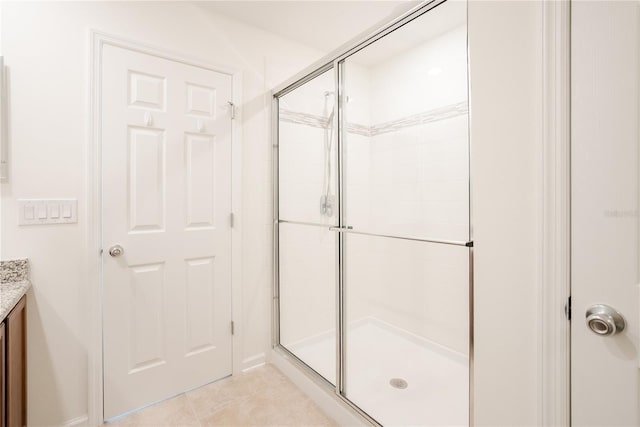 bathroom featuring a shower with door, vanity, and tile patterned flooring