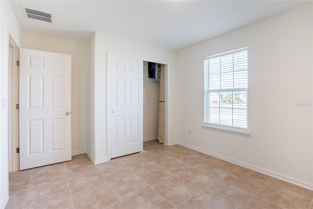 unfurnished bedroom featuring a closet and light tile patterned floors