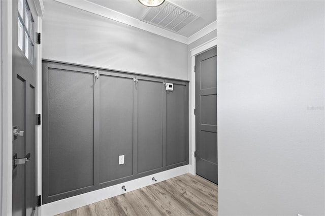 interior space with crown molding and light hardwood / wood-style flooring