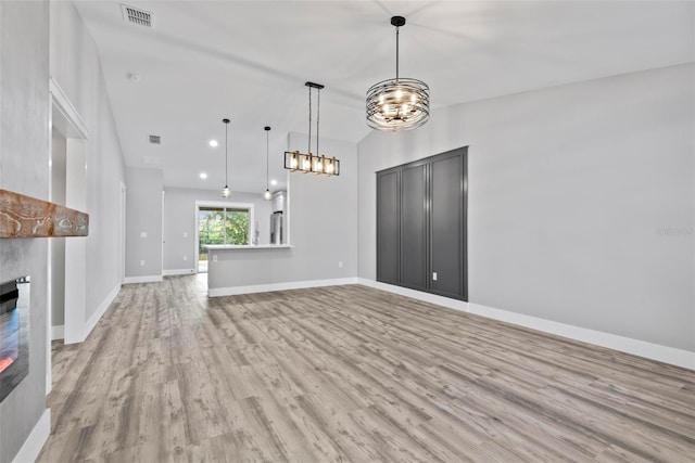 unfurnished living room with lofted ceiling and light hardwood / wood-style floors