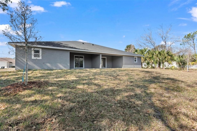 rear view of house featuring a lawn