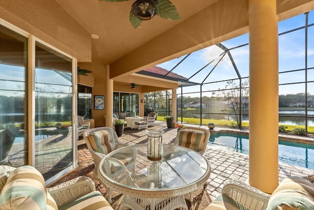 sunroom / solarium featuring a water view, plenty of natural light, a swimming pool, and a ceiling fan