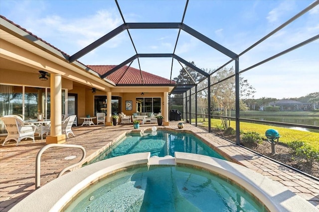 view of pool featuring glass enclosure, an outdoor living space, a pool with connected hot tub, a ceiling fan, and a patio area