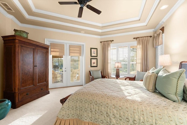 bedroom with light carpet, visible vents, access to outside, a tray ceiling, and french doors