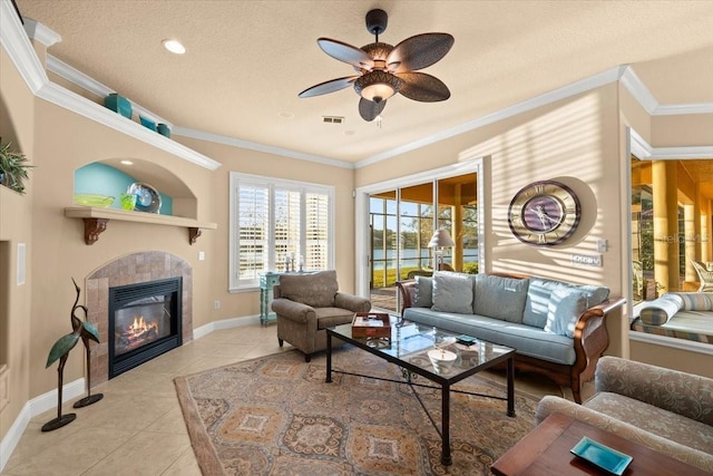 living room with visible vents, baseboards, ornamental molding, tile patterned flooring, and a fireplace