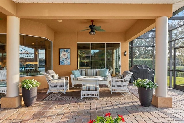 view of patio / terrace featuring glass enclosure, an outdoor living space, a ceiling fan, and area for grilling