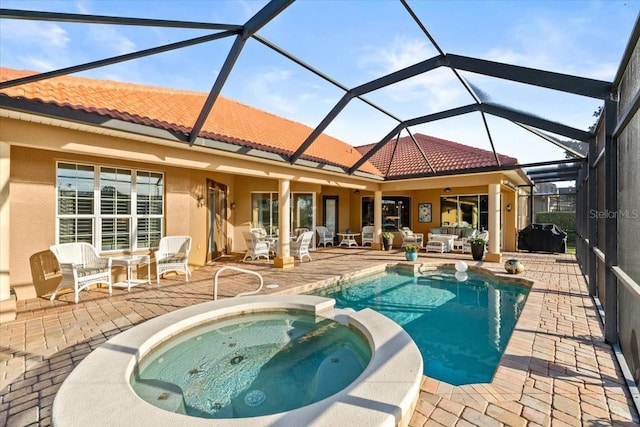 view of swimming pool with a patio area, a pool with connected hot tub, and an outdoor living space