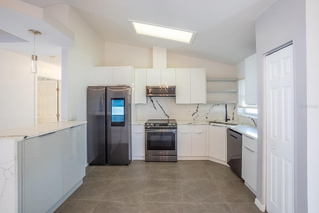 kitchen with white cabinetry, lofted ceiling, appliances with stainless steel finishes, and hanging light fixtures