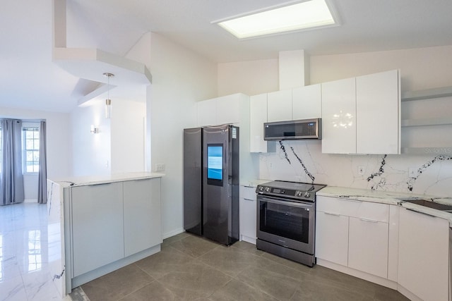 kitchen with white cabinetry, vaulted ceiling, kitchen peninsula, stainless steel appliances, and decorative backsplash