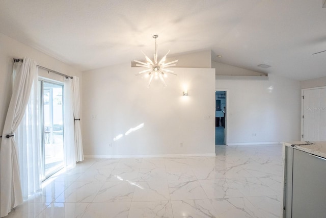 spare room featuring vaulted ceiling and a chandelier