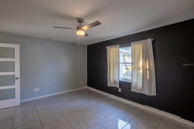 tiled spare room featuring ceiling fan